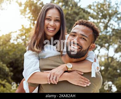 Liebe, schwarzes Paar und mit Lächeln Umarmung, Bindung und glücklich zusammen im Freien für Spaß, Liebe und Umarmung. Porträt, Romantik und Mann Piggy Rücken Frau mit Stockfoto