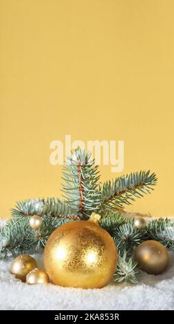 Goldene Kugeln mit Tannenzweigen, goldenen Schmuckstücken und Beeren. Zeit zehn bis Mitternacht. Dunkelgrüner Hintergrund mit Schnee. Frohe Weihnachten, Frohes neues Jahr. Stockfoto