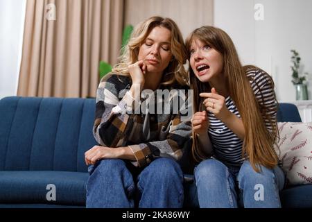 Mutter klatscht mit Tochter auf der Couch zu Hause Stockfoto
