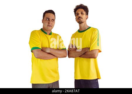 Black Brothers mit gelber brasilianischer Jubelkeuerung isoliert auf Weiß. Fußballfans jubeln über den Sieg Brasiliens. Stockfoto