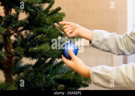 Hand hält blauen Ball Ornament Nahaufnahme. Dekoration weihnachtsbaum zu Hause .Winter Urlaub Stockfoto
