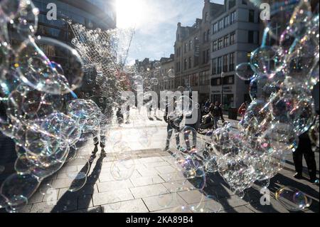 Wiesbaden, Deutschland. 01.. November 2022. Jonas produziert im Auftrag der Stadtmarketing-Abteilung Seifenblasen in der Innenstadt. Viele Rheinland-pfälzische Einwohner nutzen den Urlaub am 1. November, um im benachbarten Hessen einkaufen zu gehen. Dort ist Allerheiligen ein normaler Arbeitstag. Quelle: Sebastian Gollnow/dpa/Alamy Live News Stockfoto