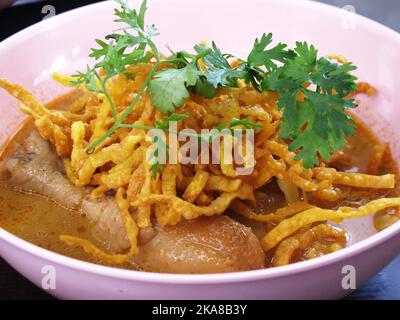 Lokale traditionelle thailändische Küche khao soi gai oder Küche nördliche thai-Kurrsuppe Nudeln mit Huhn servieren Gemüse Beilage auf Keramik Teller auf l Stockfoto