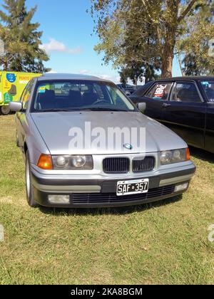 Luxus deutsche Kompaktklasse silbergrau BMW 3 Series E36 Limousine 1990s auf dem Land. Vorderansicht. Grill. Natur, Gras, Bäume. Oldtimer-Show Stockfoto