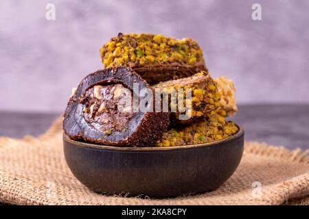 Gemischte türkische Delight-Sorten auf dunklem Hintergrund. Türkische Köstlichkeiten mit Pistazien, Haselnüssen und Früchten. Nahaufnahme Stockfoto