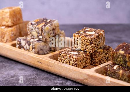 Gemischte türkische Delight-Sorten auf dunklem Hintergrund. Türkische Köstlichkeiten mit Pistazien, Haselnüssen und Früchten. Nahaufnahme Stockfoto