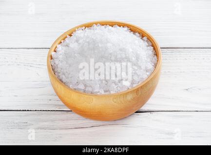 Meersalz in Holzschale auf weißer Holztisch Stockfoto