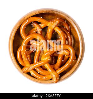 Gesalzene, harte kleine Brezeln, auch Brezel genannt, in einer Holzschale. Beliebter, traditioneller und knackiger Snack. Eine Art gebackenes Brot aus Teig. Stockfoto