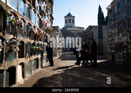 Barcelona, Spanien. 01.. November 2022. Eine Familie sah, wie sie Blumen auf ein Grab auf dem Friedhof von Sant Andreu legte. Allerheiligen, ein christlich-katholisches Fest, das auch als Allerheiligen-Fest bekannt ist, ist es in Spanien und Europa Tradition, am 1.. November Friedhöfe und Gräber von Verstorbenen zu besuchen, um den Angehörigen Respekt zu zollen, da All Souls Day, auch bekannt als Tag der Toten, Ist in der Regel kein Nationalfeiertag. Kredit: SOPA Images Limited/Alamy Live Nachrichten Stockfoto