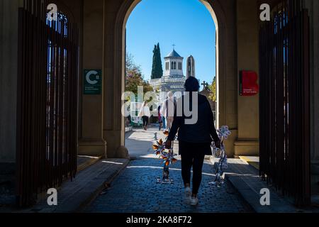 Barcelona, Spanien. 01.. November 2022. Eine Frau sah, wie sie Blumen auf dem Friedhof von Sant Andreu hielt. Allerheiligen, ein christlich-katholisches Fest, das auch als Allerheiligen-Fest bekannt ist, ist es in Spanien und Europa Tradition, am 1.. November Friedhöfe und Gräber von Verstorbenen zu besuchen, um den Angehörigen Respekt zu zollen, da All Souls Day, auch bekannt als Tag der Toten, Ist in der Regel kein Nationalfeiertag. Kredit: SOPA Images Limited/Alamy Live Nachrichten Stockfoto