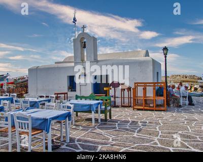 Eine schöne Aufnahme der Kirche von Agios Nikolaos im sonnigen Hafen von Naoussa auf der Insel Paros, Griechenland Stockfoto