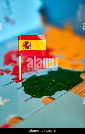 Nahaufnahme einer spanischen Flagge mit einem kleinen Stock auf der Karte Stockfoto