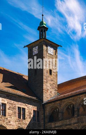 Eine vertikale Aufnahme des schönen Hofes von Schloss Plassenburg mit Uhrenturm bei Kulmbach, Bayern, Deutschland Stockfoto