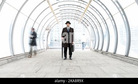 Der Stadtgent, Ein Geschäftsporträt. Ein traditioneller Londoner Geschäftsmann mit Melone Hut in einem modernen städtischen Umfeld. Aus einer verwandten Bildserie. Stockfoto
