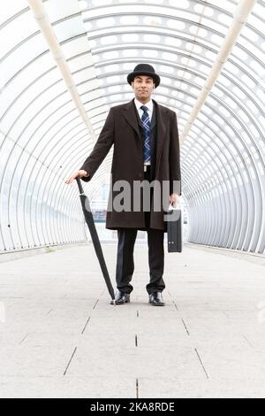 Das Stadtfest, Business Smart. Ein traditioneller Londoner Geschäftsmann mit Melone Hut in einem modernen städtischen Umfeld. Aus einer verwandten Bildserie. Stockfoto