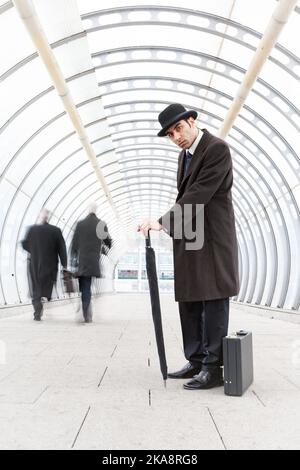 Der Stadtgent, Finanzvertrauen. Ein traditioneller Londoner Geschäftsmann mit Melone Hut und einer vorsichtigen, wachsamen Haltung. Aus einer verwandten Bildserie. Stockfoto