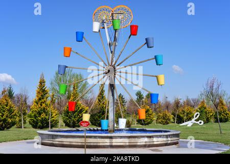 Wassermühle mit bunten Eimern im Park Stockfoto