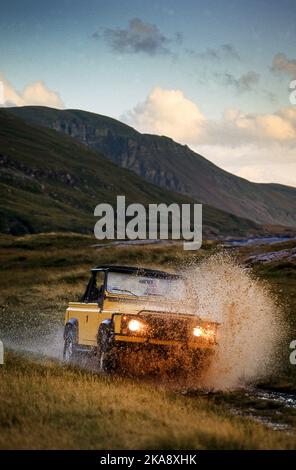 Land Rover Defender 90 V8 fährt im Gelände in Schottland, Großbritannien Stockfoto