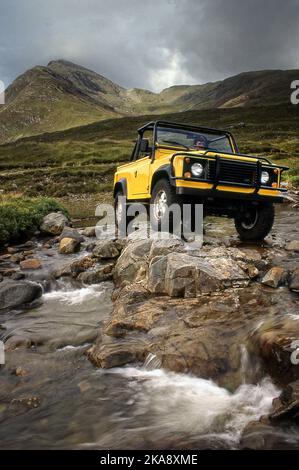 Land Rover Defender 90 V8 fährt im Gelände in Schottland, Großbritannien Stockfoto