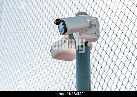 CCTV-Überwachungskamera vor dem Sperrbereich, der von Drahtgeflecht umgeben ist Stockfoto