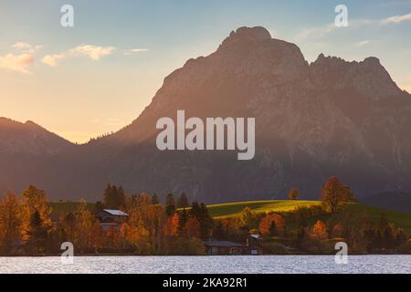 Ein Herbstaufgang am Hopfensee mit den Allgauer Alpen im Hintergrund. Das Hotel liegt in Bayern, Süddeutschland. Stockfoto