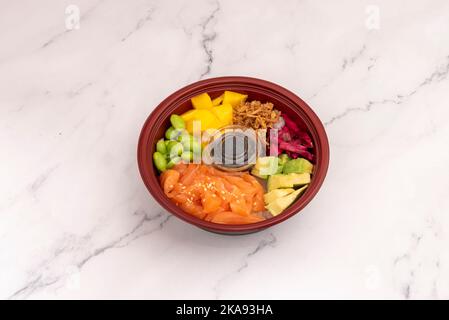 Lachs Poke Bowl, Edamame-Bohnen, gewürfelter Mango, Avocado, Rote Beete und knusprige Zwiebel und Sojasauce Stockfoto