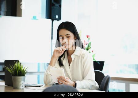 Geschäftsinhaber verwenden Rechner, um mit Finanzdokumenten zu berechnen, um Gewinne von Dritten zu analysieren, um in Aktien des Unternehmens zu investieren. Stockfoto