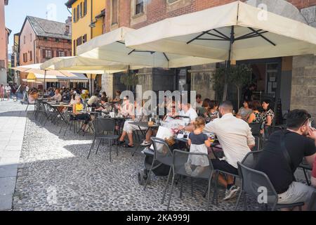 Italien Café, Blick im Sommer der Menschen entspannen auf Café-Terrassen in der Piazza San Fedele im historischen Zentrum der Stadt Como, Lombardei gelegen Stockfoto