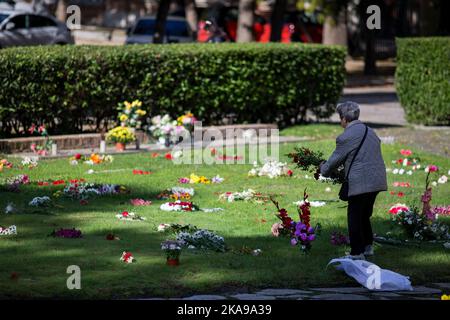 Madrid, Spanien. 01.. November 2022. Eine Frau hält einen Blumenstrauß im Garten des Gedenkens auf dem Almudena-Friedhof in Madrid, während der Feier des Allerheiligen. Es ist eine christlich-katholische Tradition, die Friedhofs und Gräber der Verstorbenen zu besuchen, um sie am Allerheiligen zu schmücken und zu erinnern. Der Almudena-Friedhof ist zu Ehren des schutzpatrons von Madrid benannt, er ist der größte Friedhof in Westeuropa. Kredit: SOPA Images Limited/Alamy Live Nachrichten Stockfoto