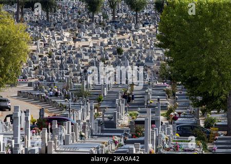 Madrid, Spanien. 01.. November 2022. Während der Feier des Allerheiligen schmücken Menschen die Gräber von Verwandten auf dem Almudena-Friedhof in Madrid mit Blumen. Es ist eine christlich-katholische Tradition, die Friedhofs und Gräber der Verstorbenen zu besuchen, um sie am Allerheiligen zu schmücken und zu erinnern. Der Almudena-Friedhof ist zu Ehren des schutzpatrons von Madrid benannt, er ist der größte Friedhof in Westeuropa. Kredit: SOPA Images Limited/Alamy Live Nachrichten Stockfoto