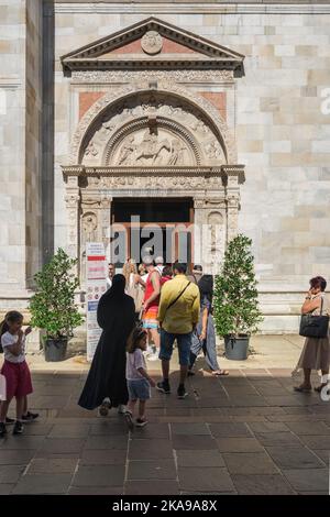 Menschen im Dom von Como, Blick auf Menschen, die in der Via Maestri Comacini Schlange stehen, um die Kathedrale von Como durch ihre Südtür, Lombardei, Italien, zu betreten Stockfoto