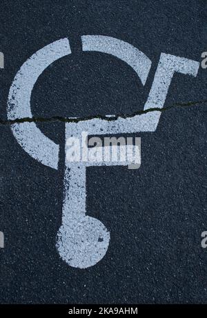 Umgekehrte Perspektive eines Schildes auf Asphalt für Behindertenparkplätze mit einer linearen Spaltkreuzung Stockfoto