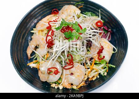 thailändischer, würziger Shrimp-Salat mit knackigem Gemüse, Erdnüssen und Bohnensprossen auf weißem Hintergrund, Draufsicht Stockfoto