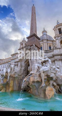 Stadtansicht von Rom, Italien: Brunnen der vier Wassermengen mit einem ägyptischen Obelisken auf dem Navon-Platz: Auf dem Hintergrund die Kirche Sant’Agnese in Agone. Stockfoto