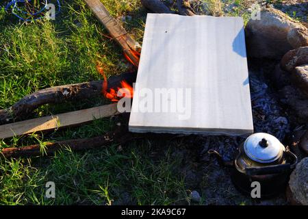 Marmor am Lagerfeuer zum Kochen und Teekannen am Feuer im Freien an einem sonnigen Sommertag Stockfoto