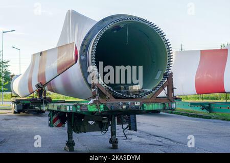 Tieflader-Sattelauflieger mit übergroßen gebrauchten Windgeneratorteilen auf dem Parkplatz Stockfoto