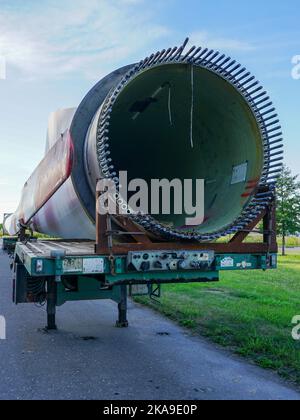 Tieflader-Sattelauflieger mit übergroßen gebrauchten Windgeneratorteilen auf dem Parkplatz Stockfoto