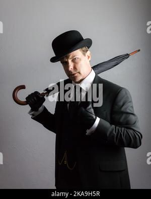 Porträt eines britischen Geschäftsmannes in Dark Suit und einem Regenschirm mit Bowler hat Holding. Vintage Style des klassischen englischen Gentleman. Stockfoto