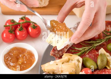 Frau, die italienische Antipasti isst. Wurstplatte mit verschiedenen Wurst- und Käsesorten - Salami, bresaola, Proscuitto, dorlu, Parmesan Stockfoto