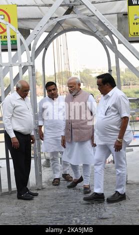 Morbi, Indien. 01.. November 2022. Der indische Premierminister Narendra Modi, Mitte, inspiziert mit lokalen Beamten die Überreste der Fußgängerbrücke von Morbi nach dem tragischen Zusammenbruch am 1. November 2022 in Morbi, Gujarat, Indien. Die kürzlich renovierte Fußgängerbrücke aus der viktorianischen Zeit brach zusammen und tötete am 30.. Oktober mindestens 135 Menschen. Kredit: Presseinformationsbüro/PIB Foto/Alamy Live Nachrichten Stockfoto