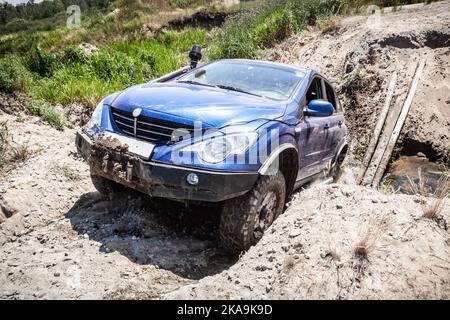 Schwerer Offroad-Rennwagen, der auf der staubigen Straße unterwegs ist. Stockfoto