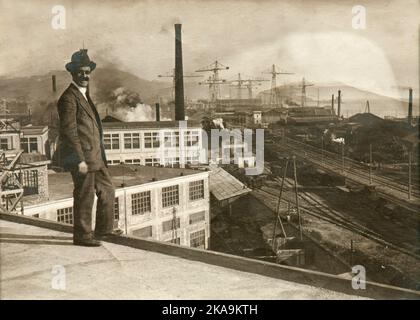 Ein eintöniger lächelnder Mann, der Mitte der zwanziger Jahre auf einem Gebäude in einem unbekannten Ort in Italien stand Stockfoto