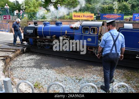 Der Fahrer, der im Begriff ist, die Dampflokomotive Whillan Beck auf dem Drehteller am Bahnhof Ravenglass zu besteigen, um Passagiere auf den 7 landschaftlich reizvollen Meilen zu befördern Stockfoto