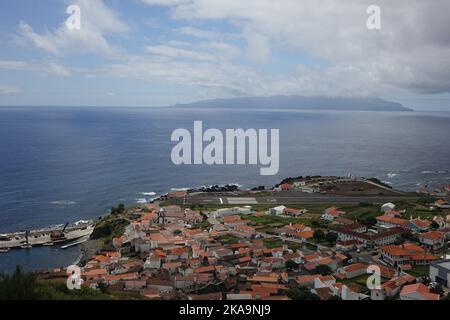 Eine Luftaufnahme der traditionellen Häuser der Insel Corvo mit einem wunderschönen Blick auf das Meer und die Insel Flores am Horizont der Azoren, Portugal Stockfoto