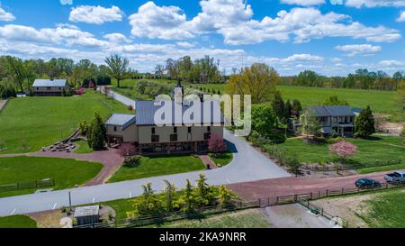 Drohne Blick auf ein Bauernhaus und Scheune auf einer wunderschönen Landschaft an einem Frühlingstag Stockfoto