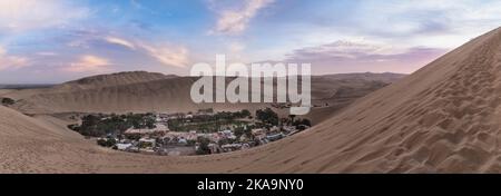 Oasis Panorama. Oasis Huacachina Panorama, ganz in der Nähe von Ica, während eines wunderschönen Sonnenuntergangs zwischen den Sanddünen. Huacachina, Ica, Peru. Stockfoto