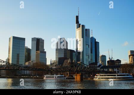 Blick auf die Skyline des Frankfurter Bankenviertels an einem sonnigen Winterabend am Mainufer. Stockfoto