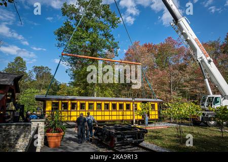 Elizabethtown, Pennsylvania, 7. Oktober 2020 - Installation eines neuen gelben Passagierfahrgastes, der von einem Kran angehoben wird, um an einem Herbsttag auf einem Eisenbahntrasse auf Zugmaschinen zu montieren Stockfoto