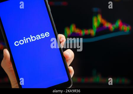 Ukraine, Odessa - Oktober, 9 2021: Coinbase mobile App läuft auf dem Smartphone-Bildschirm mit Trading Candlestick Chart im Hintergrund. Coinbase ist Amerikaner Stockfoto