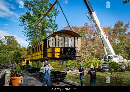 Elizabethtown, Pennsylvania, 7. Oktober 2020 - Installation eines neuen gelben Passagierfahrgastes, der von einem Kran angehoben wird, um an einem Herbsttag auf einem Eisenbahntrasse auf Zugmaschinen zu montieren Stockfoto